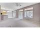 Open-concept living room with ceiling fan, carpet flooring, and seamless flow to the kitchen area at 10636 Argents Hill Dr, Las Vegas, NV 89134