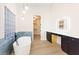 Modern bathroom featuring a soaking tub, glass block window, and vanity with elegant lighting at 10668 Porta Romana Ct, Las Vegas, NV 89141