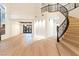 Spacious entryway featuring an ornate staircase, modern lighting, and light hardwood floors at 10668 Porta Romana Ct, Las Vegas, NV 89141