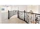 Hallway with plank floors, wrought iron bannister, and light airy aesthetic at 10668 Porta Romana Ct, Las Vegas, NV 89141