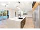 Modern kitchen with a large center island, stainless steel appliances, and backyard pool access at 10668 Porta Romana Ct, Las Vegas, NV 89141