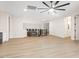 Living room featuring ceiling fan, plank flooring, and wrought iron bannister in background at 10668 Porta Romana Ct, Las Vegas, NV 89141