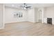 Open floor plan featuring a ceiling fan, light plank flooring and bright natural light at 10668 Porta Romana Ct, Las Vegas, NV 89141