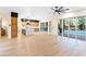 Open concept living room and kitchen area featuring sleek hardwood floors and backyard pool view at 10668 Porta Romana Ct, Las Vegas, NV 89141