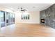 Spacious living room with modern floors, fireplace, large sliding glass doors and view to outdoor pool area at 10668 Porta Romana Ct, Las Vegas, NV 89141
