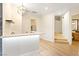 Bright living space features light wood floors, modern lighting, and seamless access to the bathroom and laundry room at 10668 Porta Romana Ct, Las Vegas, NV 89141