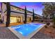 Backyard pool with stone trim, landscaped area and outdoor fireplace in luxury backyard at 10668 Porta Romana Ct, Las Vegas, NV 89141