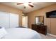 Bedroom with ceiling fan, closet, television and neutral paint and carpet at 1081 Via Gandalfi, Henderson, NV 89011