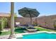 Backyard pool area featuring an umbrella, seating and a modern fountain providing a peaceful outdoor experience at 1081 Via Gandalfi, Henderson, NV 89011