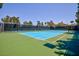 Well-maintained tennis court with a green surface, blue in-bounds, and black net for recreational games at 1081 Via Gandalfi, Henderson, NV 89011