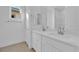 Modern bathroom featuring double sinks, white cabinets, marble counters, and a large mirror at 11049 Concord Valley Drive, Las Vegas, NV 89135