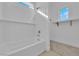 A bright, white bathtub with chrome fixtures and a tiled wall with a small window at 11049 Concord Valley Drive, Las Vegas, NV 89135