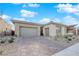 Beautiful exterior showing a three-car garage and modern landscaping with a stone driveway at 11049 Concord Valley Drive, Las Vegas, NV 89135