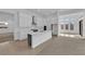 Modern kitchen featuring a large island, stainless steel appliances, and ample cabinet space, with living area views at 11049 Concord Valley Drive, Las Vegas, NV 89135