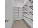 Walk-in pantry featuring built-in white shelving and tile flooring at 11049 Concord Valley Drive, Las Vegas, NV 89135