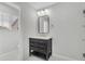 Modern bathroom with a black vanity, marble countertops, and a well-lit mirror at 1109 Maserati Dr, Las Vegas, NV 89117
