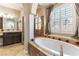 Bright bathroom features a soaking tub and a walk-in shower with glass doors at 11228 Hedgemont Ave, Las Vegas, NV 89138