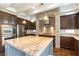Kitchen with island and granite countertops features stainless appliances and dark wood cabinetry at 11228 Hedgemont Ave, Las Vegas, NV 89138