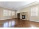 Inviting living room with stone fireplace, hardwood floors, and sunlit windows with plantation shutters at 11228 Hedgemont Ave, Las Vegas, NV 89138