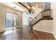 Spacious living room showcasing hardwood floors, elegant staircase, and a stylish chandelier, filled with natural light at 11228 Hedgemont Ave, Las Vegas, NV 89138
