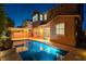 Beautiful backyard pool area with patio, string lights, and home's elevation at dusk at 11228 Hedgemont Ave, Las Vegas, NV 89138