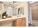 Well-lit bathroom featuring a large mirror, a vanity area, and a shower-tub combination at 11278 Tenza Ct, Las Vegas, NV 89141