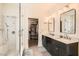 Modern bathroom featuring double sinks, walk-in shower and a walk-in closet at 11278 Tenza Ct, Las Vegas, NV 89141