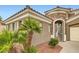 Mediterranean entrance with an arched stone portico, metal gate and tropical landscaping at 11278 Tenza Ct, Las Vegas, NV 89141