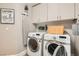 A well-equipped laundry room with appliances and storage cabinets at 11278 Tenza Ct, Las Vegas, NV 89141