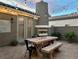 Outdoor patio with a wooden table and chairs, fireplace, string lights, and tiled flooring, perfect for entertaining at 11278 Tenza Ct, Las Vegas, NV 89141
