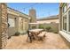 Outdoor patio area with fireplace, tile flooring, and wooden dining table at 11278 Tenza Ct, Las Vegas, NV 89141