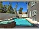 Backyard featuring a sparkling pool and jacuzzi with stone accents, surrounded by a patio and privacy fence at 11278 Tenza Ct, Las Vegas, NV 89141