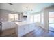 Open kitchen with white cabinets, stainless appliances, tile backsplash, and an island with countertop at 1620 Western Lily St, Las Vegas, NV 89128