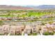 Expansive aerial view showcasing a meticulously landscaped neighborhood, complete with a golf course and mountain views at 1887 Hollywell St, Las Vegas, NV 89135