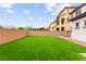 A fully enclosed backyard with lush artificial grass and a paved patio area at 1887 Hollywell St, Las Vegas, NV 89135
