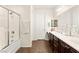 Well-lit bathroom features double sinks, dark wood cabinetry, and a shower-tub combo, providing a functional and inviting space at 1887 Hollywell St, Las Vegas, NV 89135