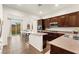 Bright, open kitchen features dark wood cabinetry, a center island and a breakfast nook with backyard views at 1887 Hollywell St, Las Vegas, NV 89135