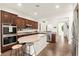 Modern kitchen featuring stainless steel appliances, granite countertops, an island, and dark wood cabinets at 1887 Hollywell St, Las Vegas, NV 89135