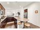 Well-lit kitchen features dark cabinets, stainless steel appliances, and a counter with seating, perfect for casual dining at 1887 Hollywell St, Las Vegas, NV 89135