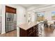 Kitchen and dining area with island seating, modern stainless steel refrigerator, and backyard views through the dining area at 1887 Hollywell St, Las Vegas, NV 89135