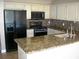 Kitchen with black appliances, granite countertops, and mosaic backsplash at 1927 Raspberry Hill Rd, Las Vegas, NV 89142
