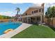 Inviting backyard featuring a sparkling pool with spa, covered patio, and low-maintenance artificial grass at 2113 Waterbury Ln, Las Vegas, NV 89134