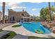 Resort-style backyard with a lagoon-shaped pool, rock waterfall, tanning ledge, and lush landscaping at 2113 Waterbury Ln, Las Vegas, NV 89134