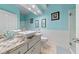 A well-lit bathroom with ocean blue walls, dual vanity sinks and framed mirrors at 2113 Waterbury Ln, Las Vegas, NV 89134