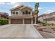 Charming two-story home features a three-car garage, desert landscaping, and a walkway to the front door at 2113 Waterbury Ln, Las Vegas, NV 89134