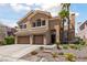 Two-story house boasts a three-car garage, mature landscaping, and stone walkway to the entryway at 2113 Waterbury Ln, Las Vegas, NV 89134