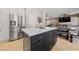Stylish kitchen island with marble countertop, dark cabinetry and seating with view to dining and living rooms at 2113 Waterbury Ln, Las Vegas, NV 89134