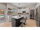 A modern kitchen with white cabinets, stainless steel appliances and view of pool through large window at 2113 Waterbury Ln, Las Vegas, NV 89134