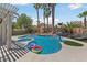This backyard features a beautiful pool, complete with a spa and mature palm trees at 2113 Waterbury Ln, Las Vegas, NV 89134