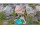 Aerial view of the backyard featuring a pool, spa, covered patio, and lush landscaping at 2445 Rue Royale, Henderson, NV 89044